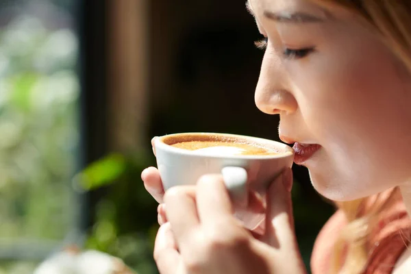 Женщина наслаждается кулаком кофе — стоковое фото