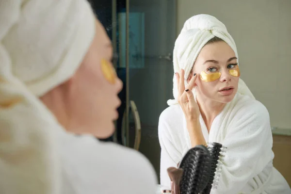 Mujer aplicando parches debajo de los ojos — Foto de Stock