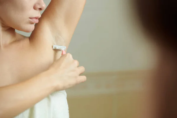 Женское бритье в ванной комнате — стоковое фото