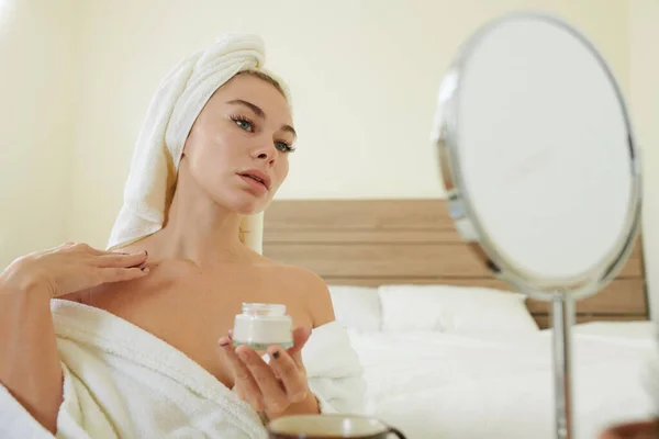 Mujer aplicando loción corporal en el pecho — Foto de Stock