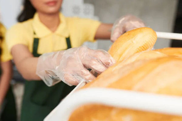 Verkäufer wählt Brot für Sandwich — Stockfoto