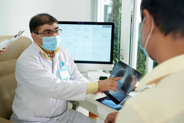 Lekarz pokazuje prześwietlenie pacjentowi — Zdjęcie stockowe