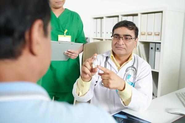 Médico mostrando vacuna al paciente — Foto de Stock