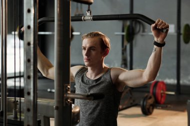 Sporcu, Aşağı Çekme Makinesinde Egzersiz Yapıyor