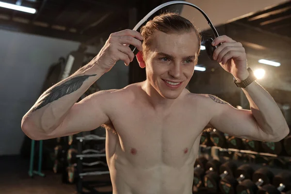 Fit Man nosi słuchawki w siłowni — Zdjęcie stockowe