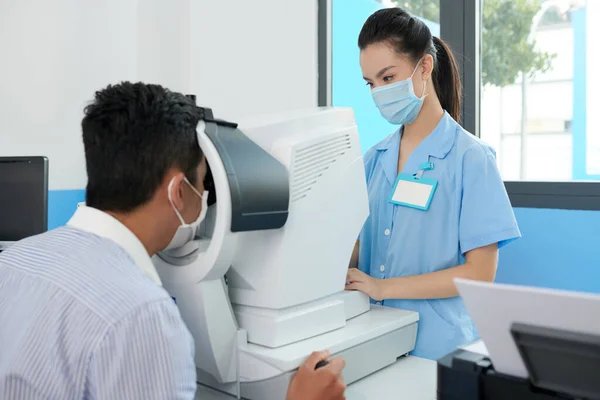 Optometrist onderzoekt ogen van patiënt — Stockfoto