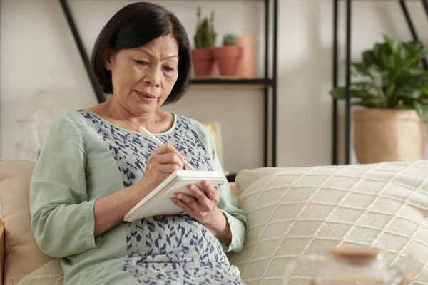 Senior vrouw die plannen opschrijft — Stockfoto