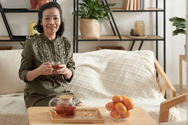 Starší žena pije čaj doma — Stock fotografie