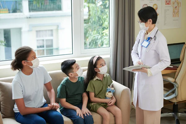 Pediatra hablando con niños en el hospital — Foto de Stock