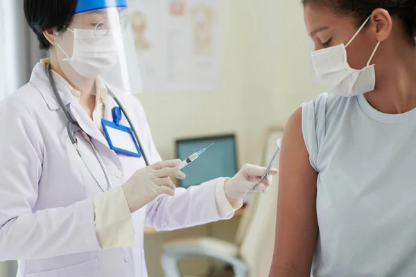 Doctor making injection to girl in clinic — Stock Photo, Image