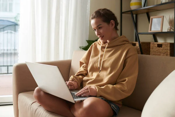 Jovem mulher usando laptop em casa — Fotografia de Stock