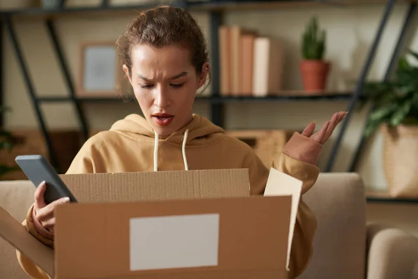 Mujer disgustada abriendo el paquete — Foto de Stock