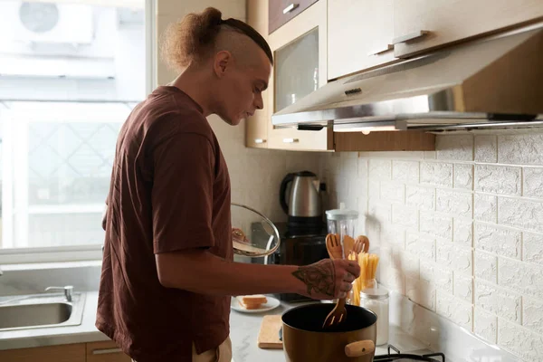 Homem cozinhando massa para o almoço — Fotografia de Stock