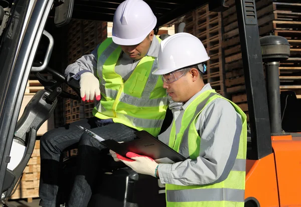 Manager talking with forklift operator — Stock Photo, Image