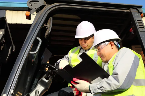 Manager talking to forklift operator — Stock Photo, Image