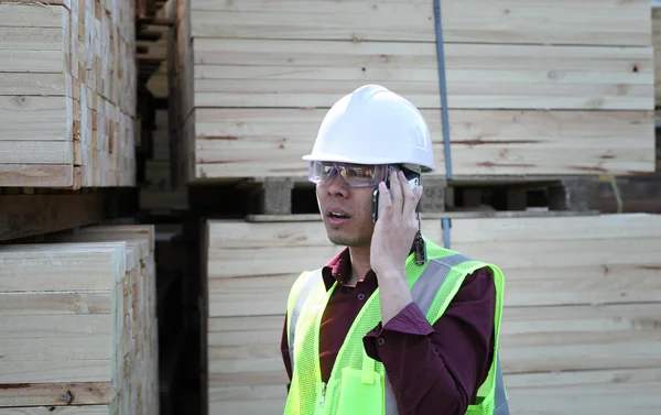 Stapelen hout en workman — Stockfoto