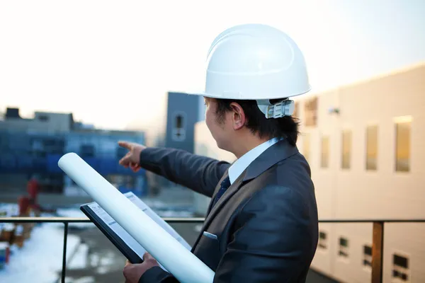 Junge Architektin zeigt auf den Hochbau — Stockfoto