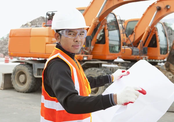 Road construction worker in front of excavator — Stock Photo, Image