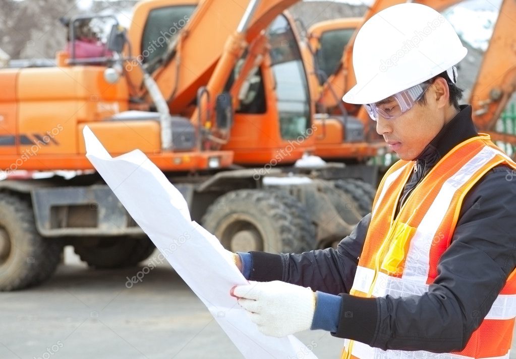 road construction worker with heavy equipment on the background