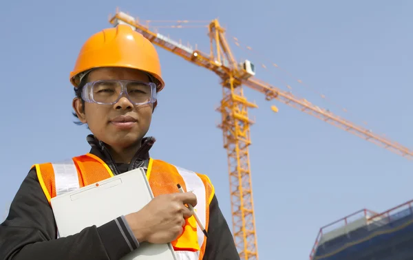 Byggnadsarbetare med kran i bakgrunden — Stockfoto