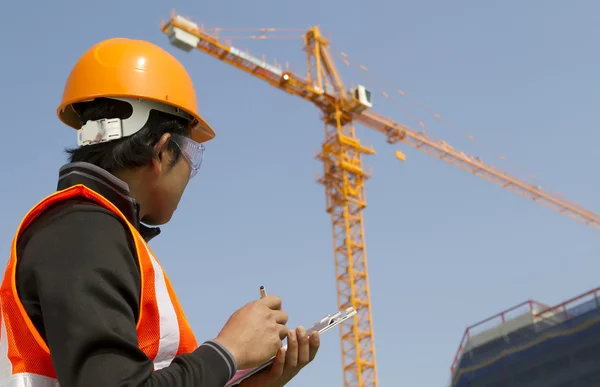 Trabajador de la construcción con grúa en segundo plano — Foto de Stock