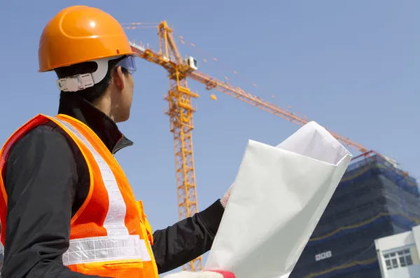 Trabalhador da construção com guindaste no fundo — Fotografia de Stock