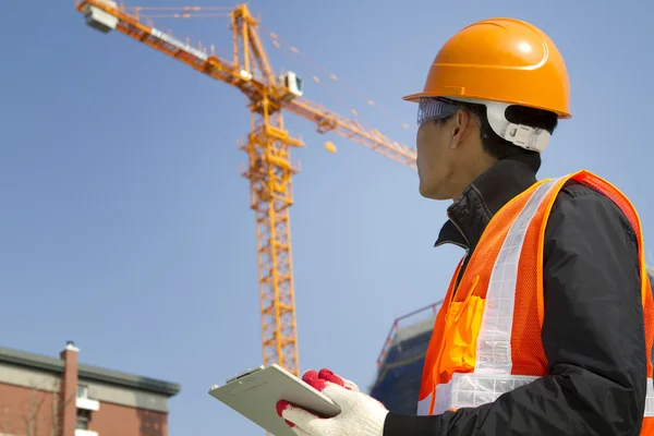 Trabalhador da construção com guindaste no fundo — Fotografia de Stock