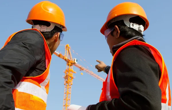 Responsabile cantiere con discussione giubbotto di sicurezza in costruzione — Foto Stock