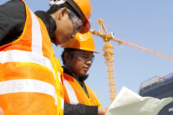 Werknemers in de bouw met kraan op achtergrond — Stockfoto