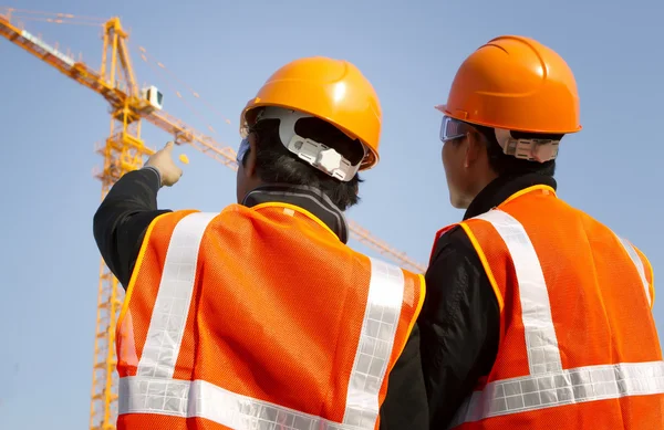 Travailleurs de la construction avec grue en arrière-plan — Photo