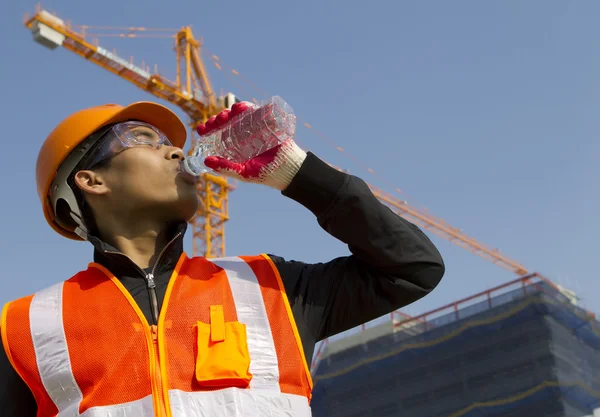 Arbetstagaren mannen som han drinkar från en plast flaska — Stockfoto