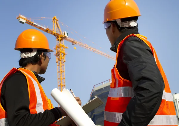 Travailleurs de la construction avec grue en arrière-plan — Photo