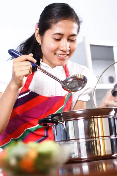 Asian woman tasting her cooking — Stock Photo, Image