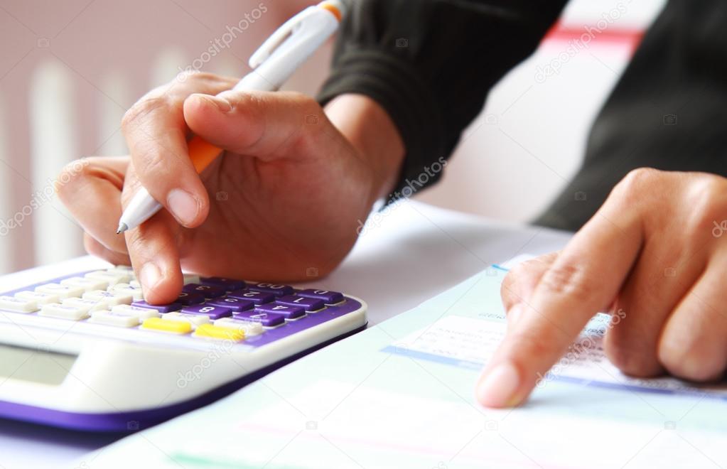 Woman's hands with a calculator and a pen