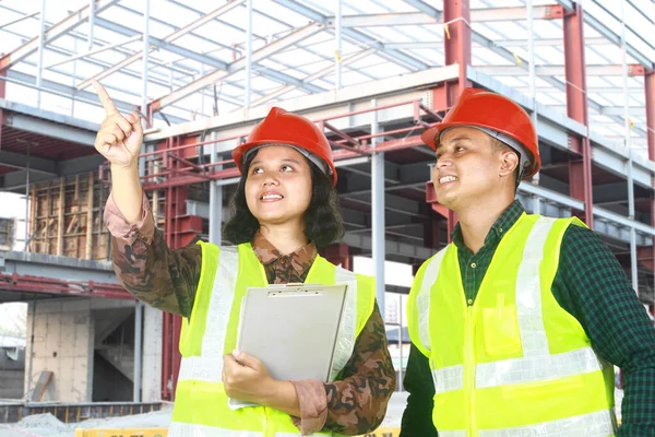 Two Construction Workers Foreman Discussing Site Pointing Finger Stockbild