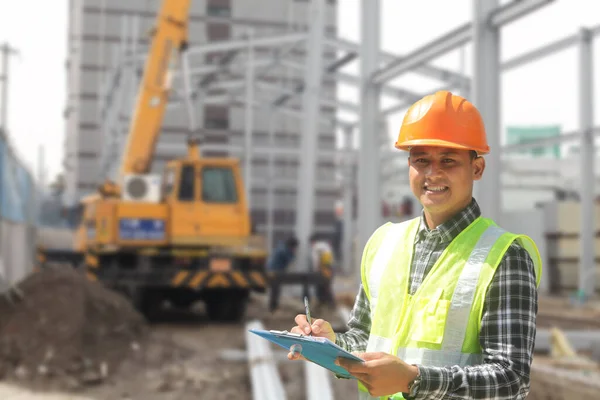 Capataz Trabajador Construcción Pie Escrito Portapapeles Sonriendo Mirando Cámara Contra —  Fotos de Stock