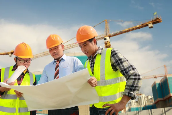 Teamwork Bauarbeiter Diskutieren Über Arbeitspläne Und Halten Baupläne Vor Dem lizenzfreie Stockbilder