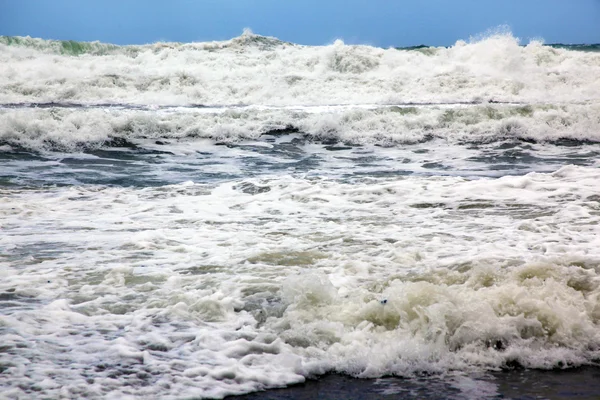 Zand en golven op het strand — Stockfoto