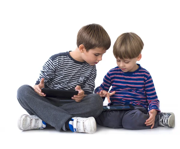 Barnen spelar TV-spel på tabletter datorer — Stockfoto