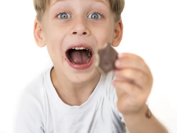 Мальчик ест шоколад — стоковое фото