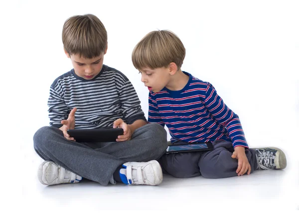 Dos hermanos jugando en las tabletas —  Fotos de Stock