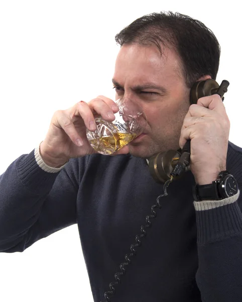 Человек с старый телефон пьет виски  — стоковое фото