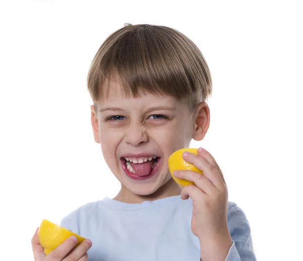 Мальчик ест лемон — стоковое фото