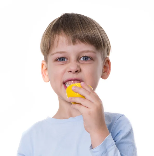 En pojke som äter citron — Stockfoto