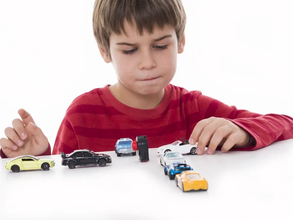 Niño jugando con pequeños coches —  Fotos de Stock