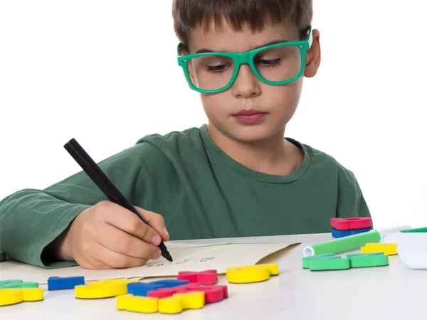 Jonge jongen zijn huiswerk schrijven — Stockfoto