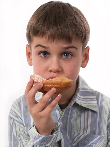 Pojke äter munk — Stockfoto