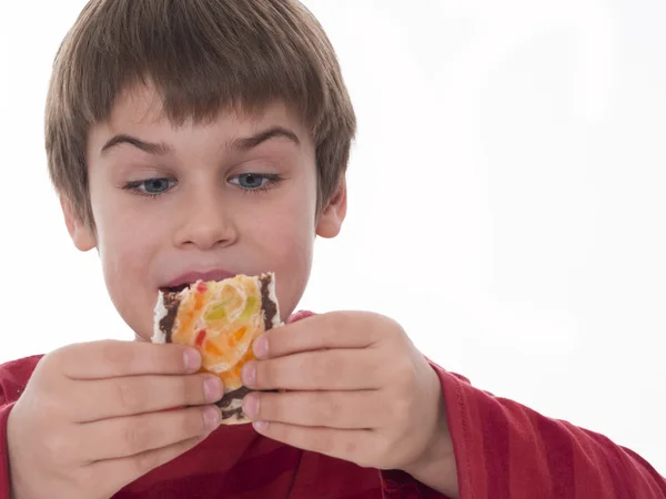 Chico comiendo, pedazo de pastel de buen gusto — Foto de Stock