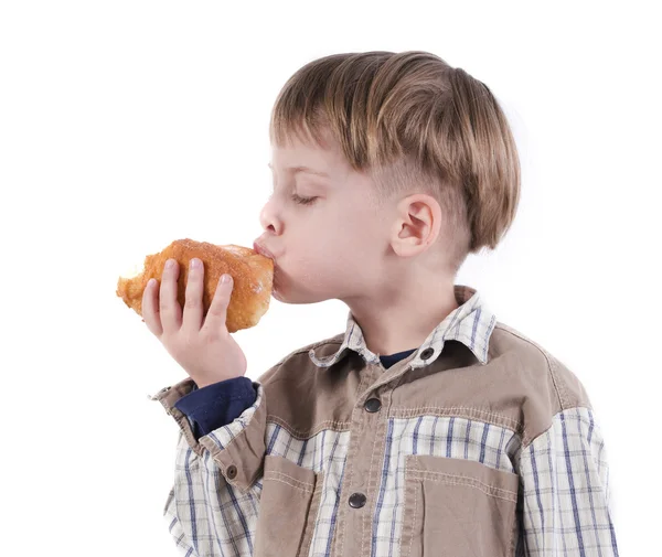 Jongen eet een donut — Stockfoto