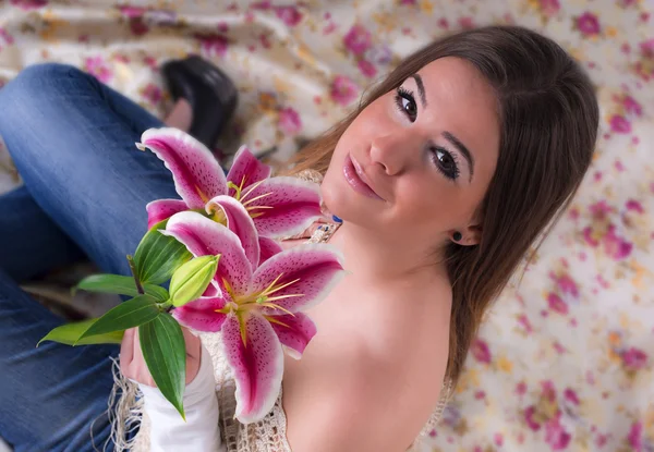 Schöne junge Frau mit Blume, trägt Jeans — Stockfoto